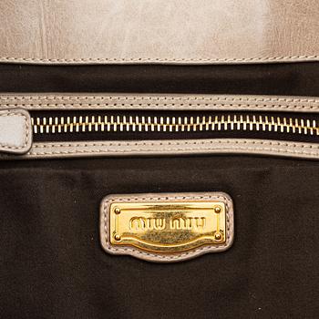Miu Miu, a light leather handbag.
