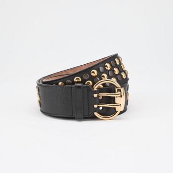 GUCCI, a black leather belt with goldcolored and patinated decor.