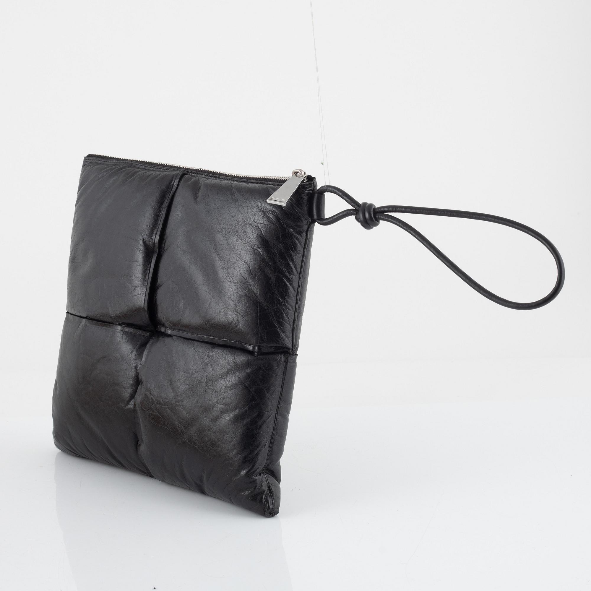 Bottega Veneta, a black leather handbag.