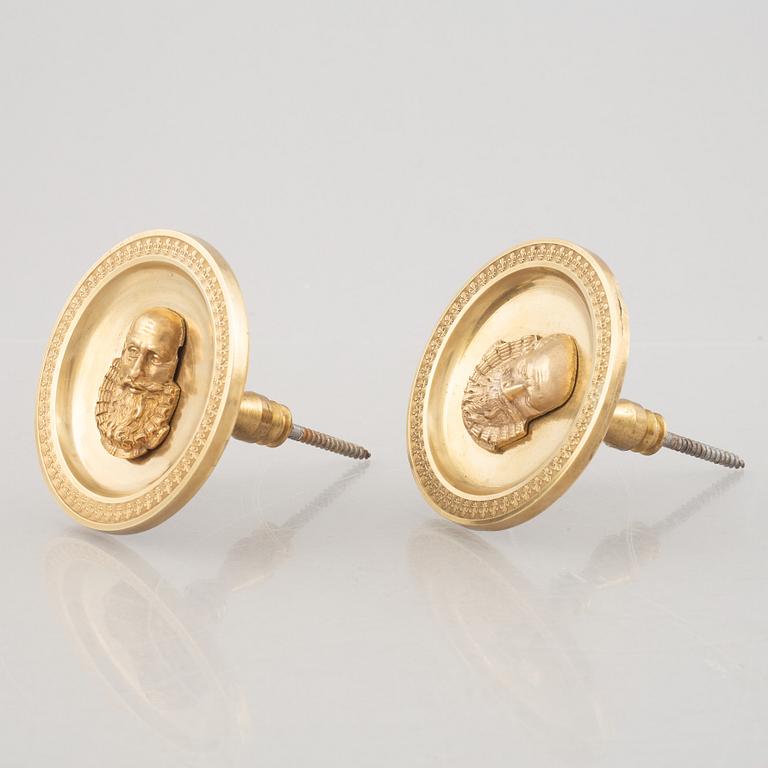 A pair of gilt-bronze Empire-style curtain holders, 19th century.