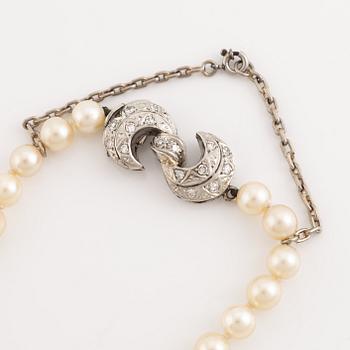 A cultured pearl necklace witk an 18K gold clasp set with eight-cut diamonds.