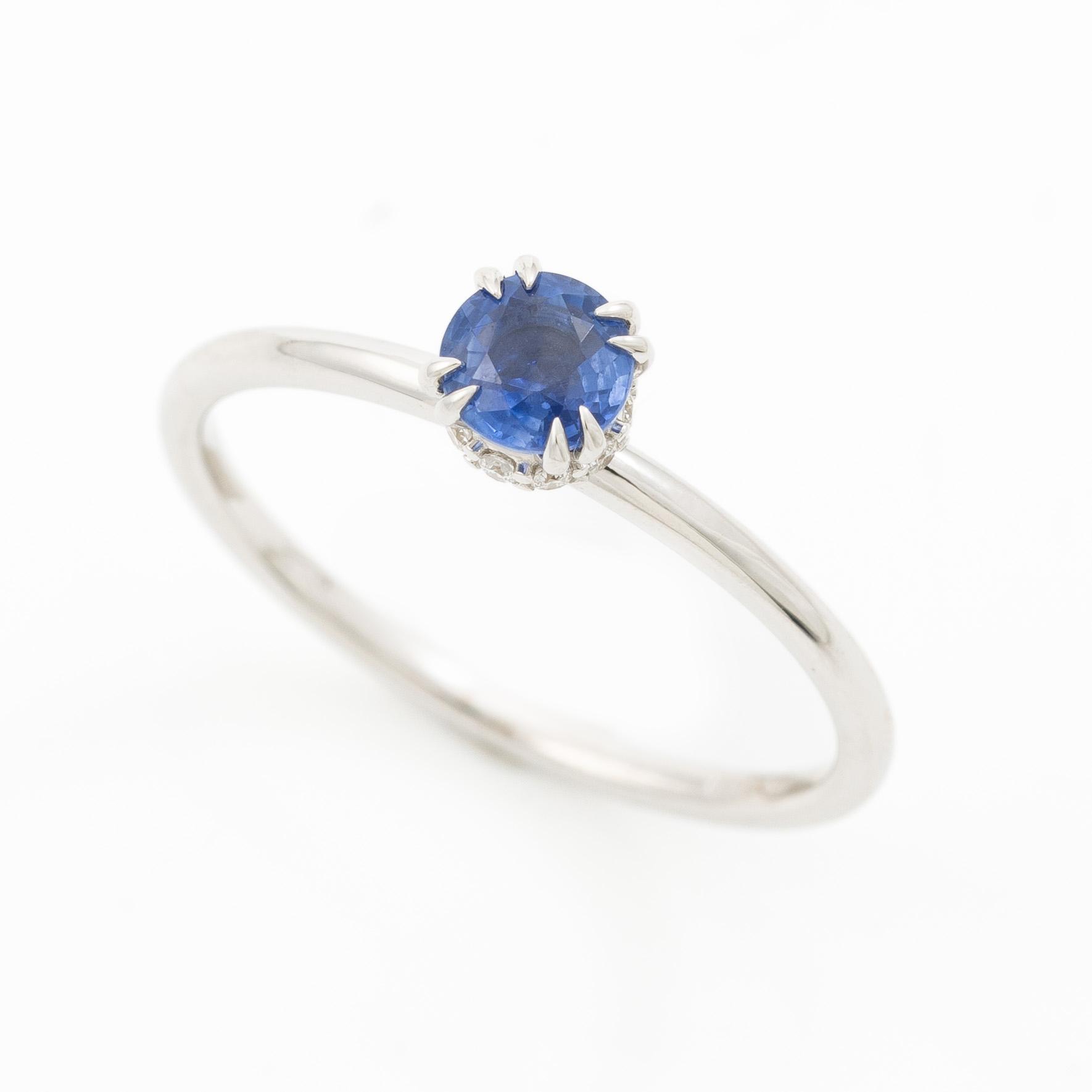 Ring 14K white gold with a sapphire and small brilliant-cut diamonds.
