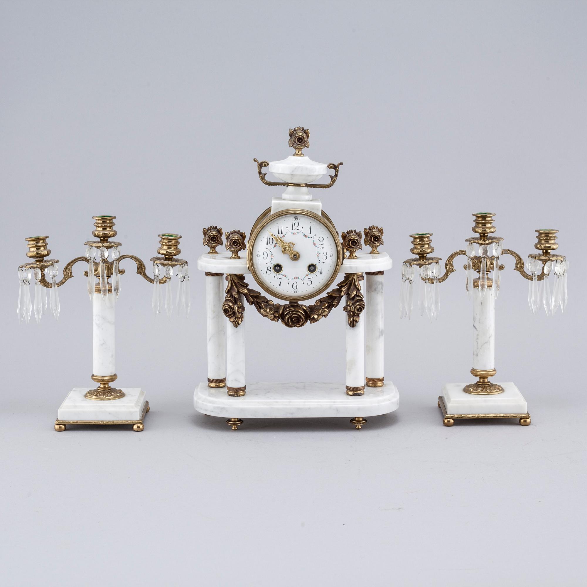 A French mantlepiece clock and a pair of candelabras, first half of the 20th century.