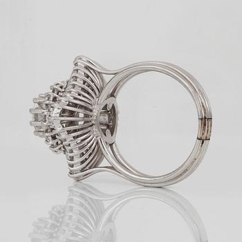 A brilliant- and trapezoid-cut diamond ring. Center diamond circa 1.10 cts and surrounding diamonds circa 1.00 ct.