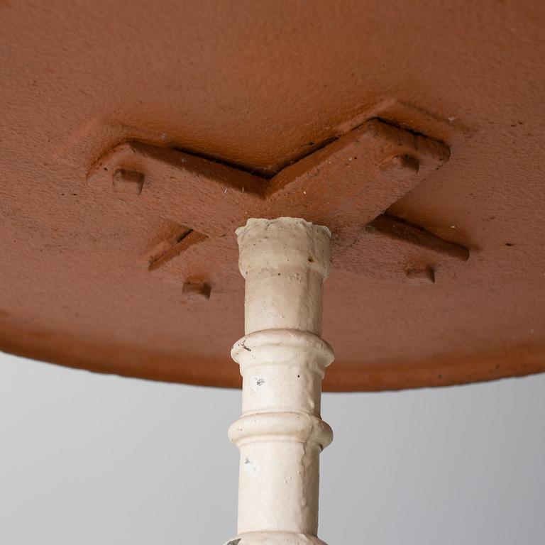 A pair of cast iron chais with wooden seats and a cast iron table, early 20th century.