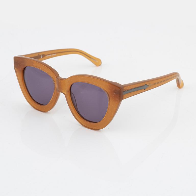 Karen Walker, a pair of orange glitter "Anytime" sunglasses.