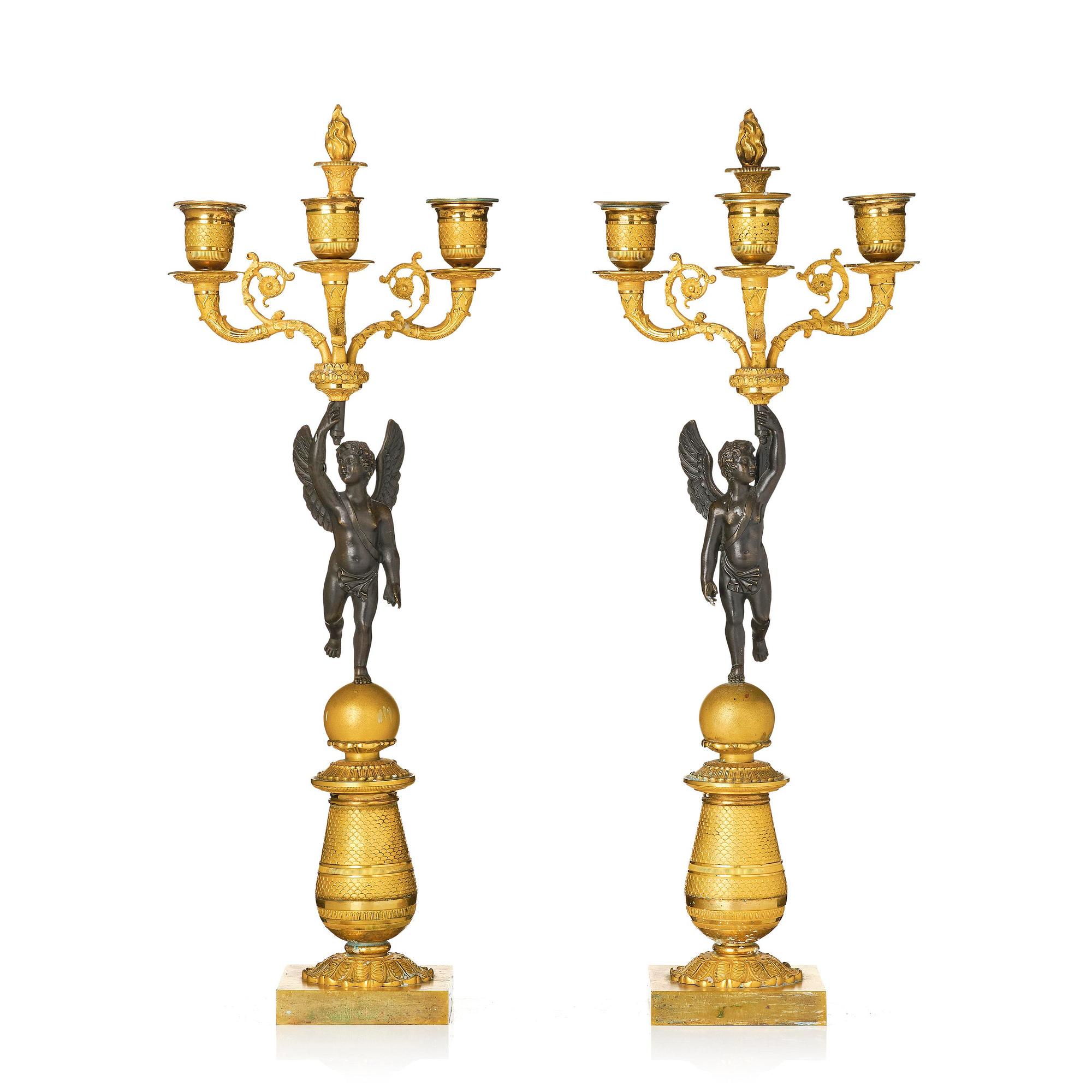A pair of Empire three light ormolu and patinated bronze candelabra.