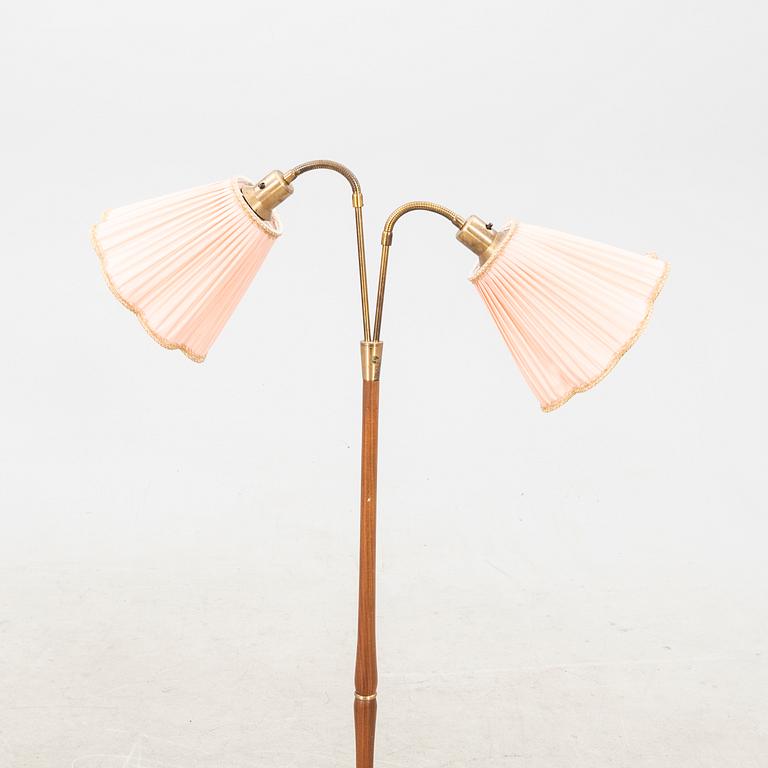 A teak and brass floor lamp from the first half of the 20th century.
