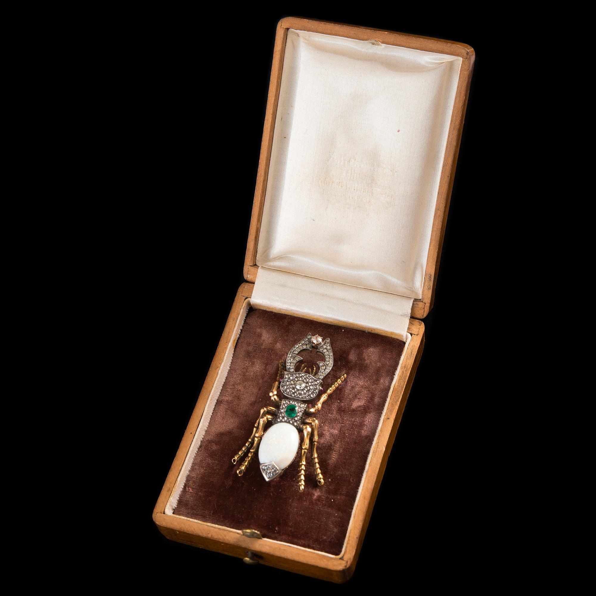BROSCH, opal ca 13.00 ct, smaragd ca 0.5 ct, antikslipade diamanter ca 1.6 ct, rubiner.