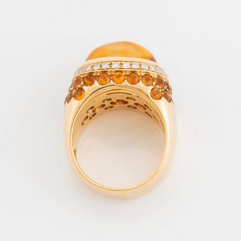 An 18K gold ring set with a cabochon-cut citrine and round brilliant-cut diamonds och citrines.