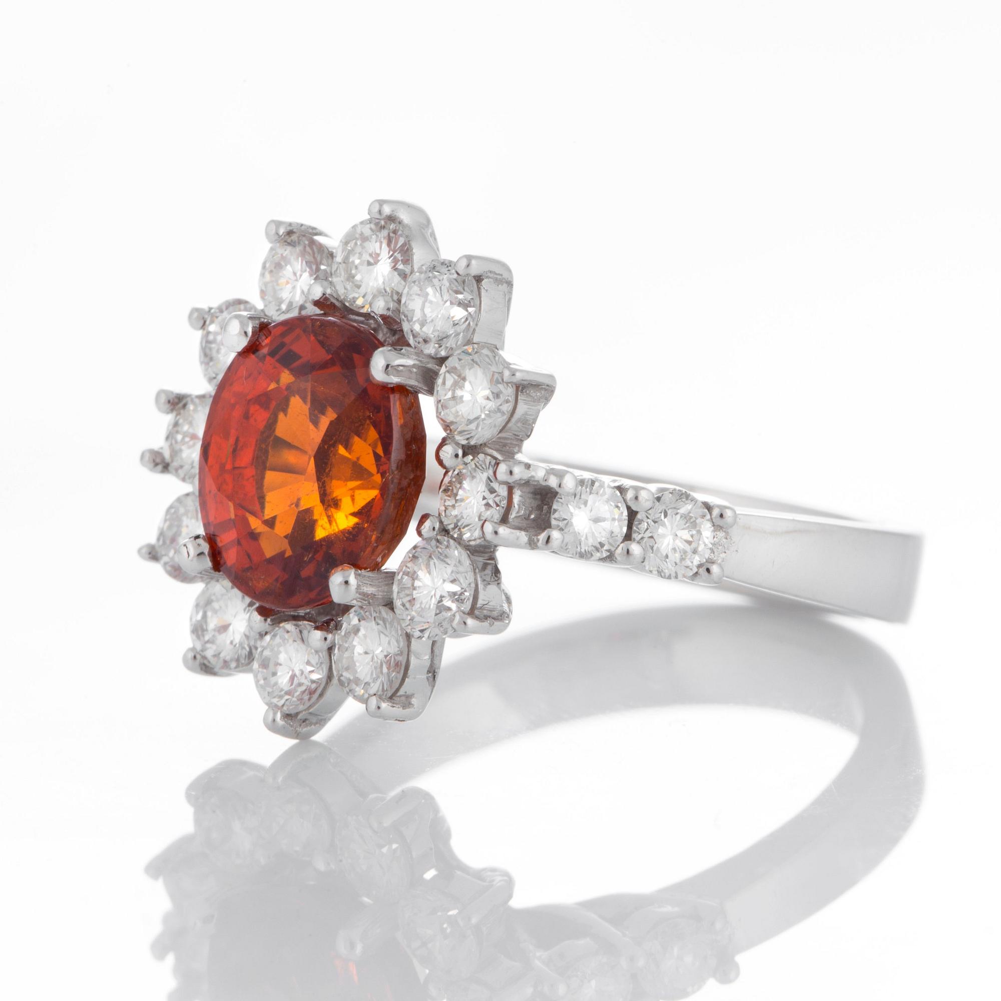 Ring med en fasettslipad spessartingranat samt runda briljantslipade diamanter.