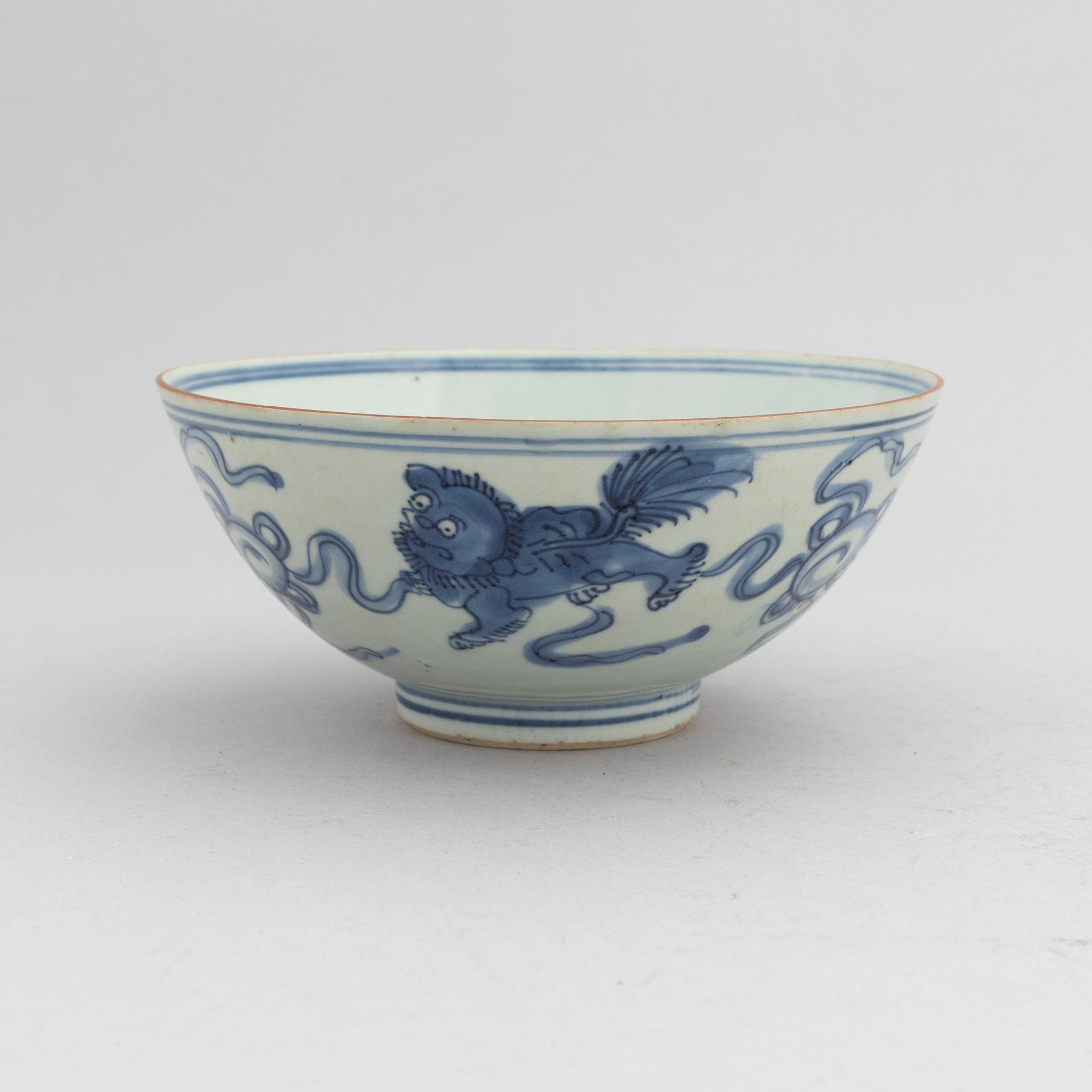 A Chinese blue and white porcelain bowl with buddhist lions chasing a ball with ribbons, Ming dynasty (1368-1644).