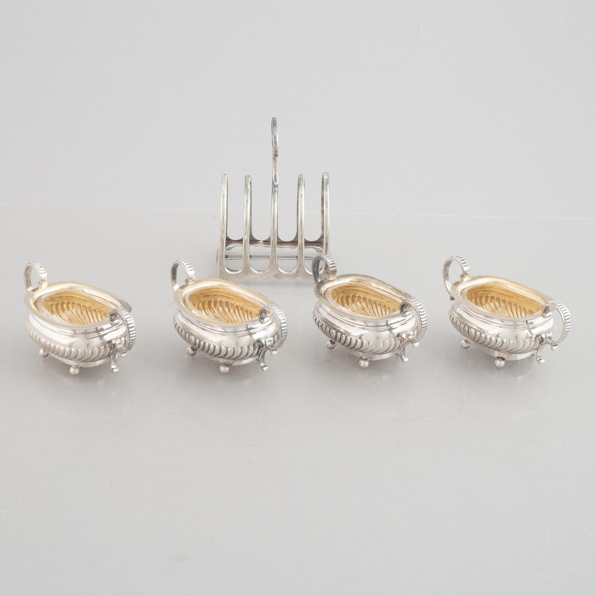 A set of four English silver salt cellars and a toast rack, including Roberts & Belk, Sheffield, England 1898.