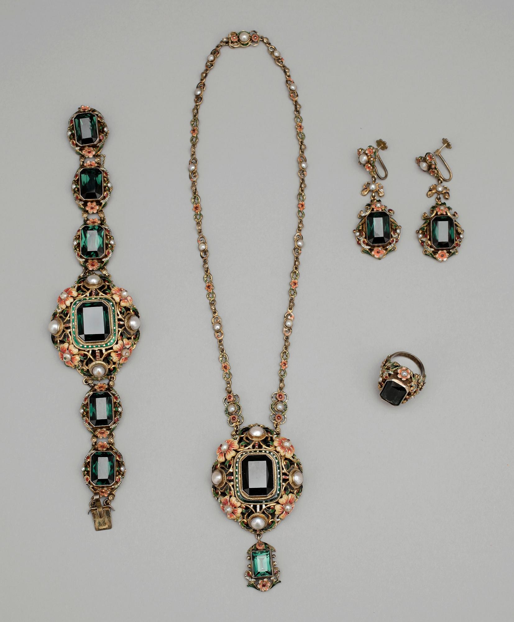 GARNITYR, 4 delar, silver och färgade glasstenar, emalj samt pärlor. Märkt PV. 1900-talets början.