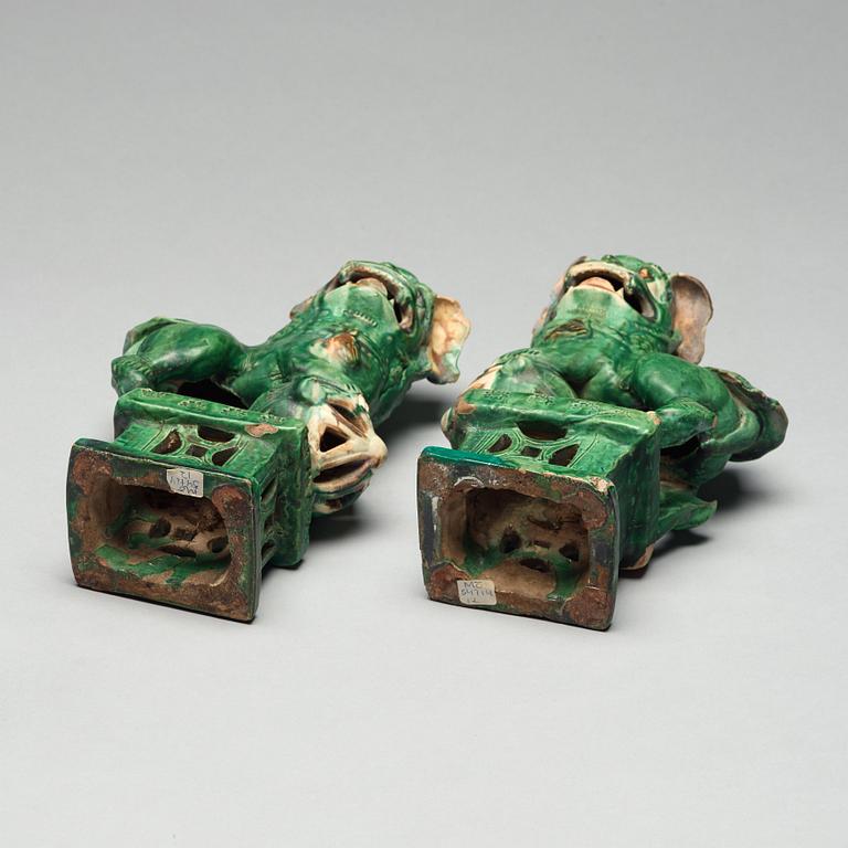 A pair of green glazed buddhist lions, Ming dynasty (1368-1644).