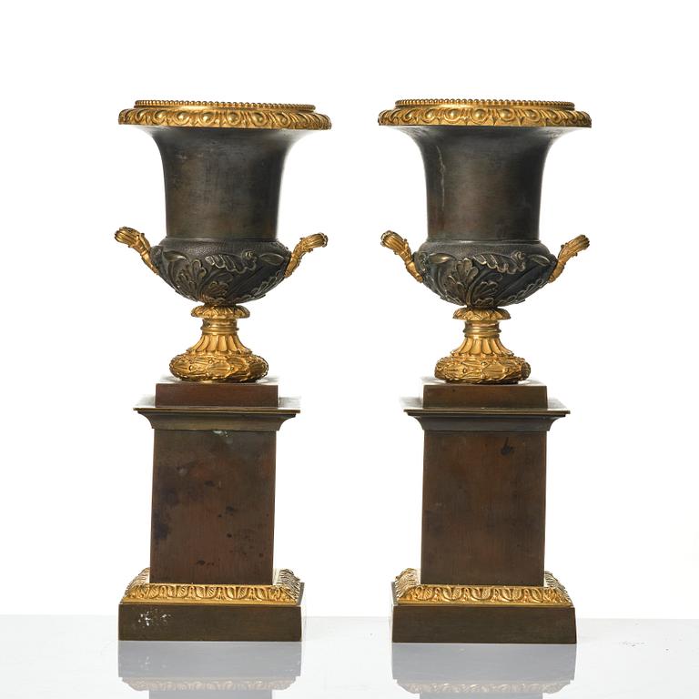 A pair of French Louis Philippe gilt and patinated bronze urns, first part 19th century.