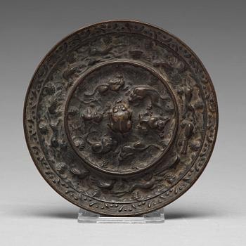 573. A lion and grapewine bronze mirror, Tang dynasty (618-907).