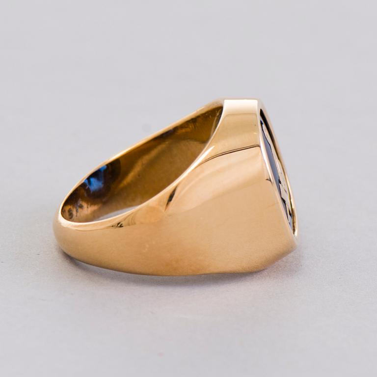 A gold 18K Freemason ring with a synthetic blue sapphire.