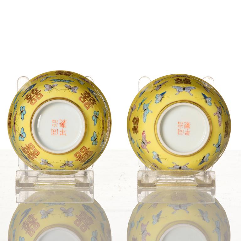 A pair of yellow glazed double happiness cups with butterflies, Qing dynasty, with Tongzhis four character mark to base.