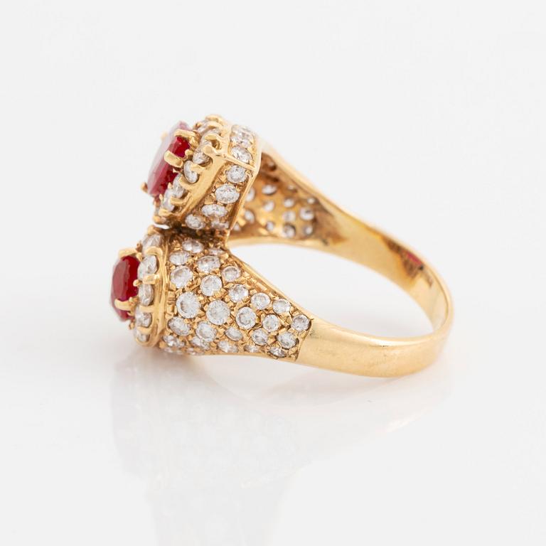 An 18K gold ring set with two facted rubies and round brilliant-cut diamonds.