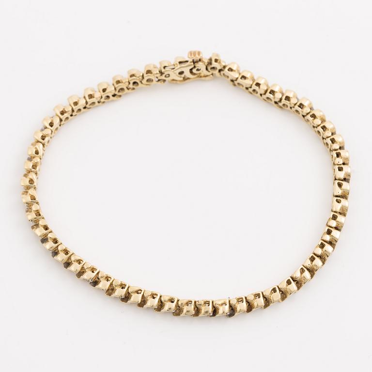 Tennis bracelet 14K gold with round brilliant-cut diamonds.