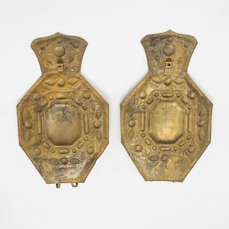 A pair of Baroque style brass wall sconces form around the year 1900.