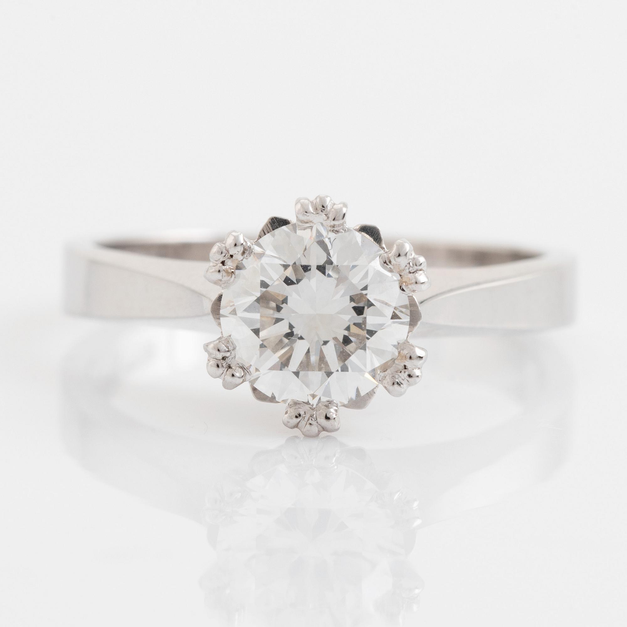 An 18K white gold ring set with a round brilliant-cut diamond.