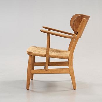 A Hans J Wegner 'CH-22' oak easy chair, Carl Hansen & Son, Odense, Denmark.