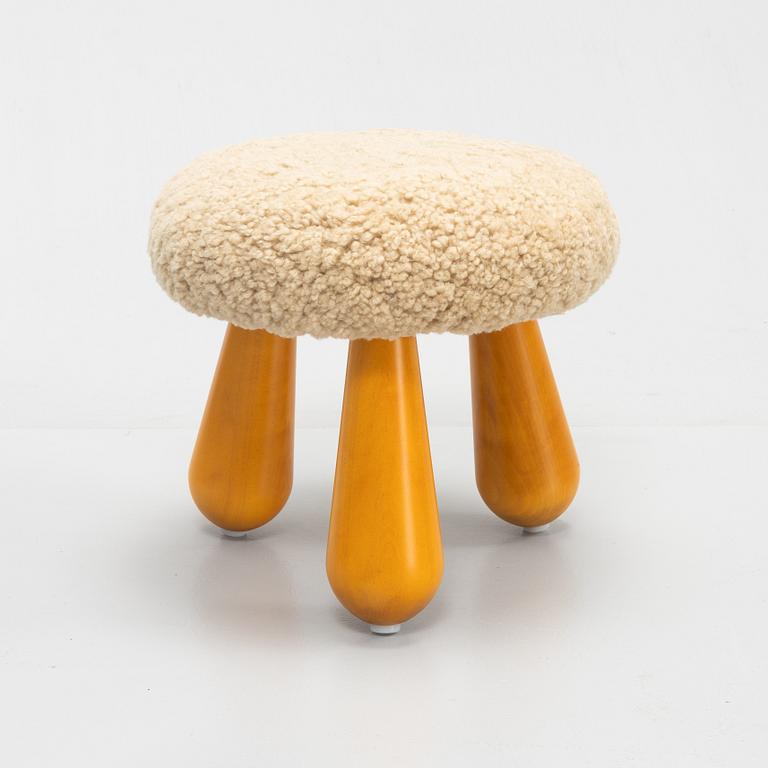 A Swedish, new produced stool with birch legs and sheepskin upholstery.