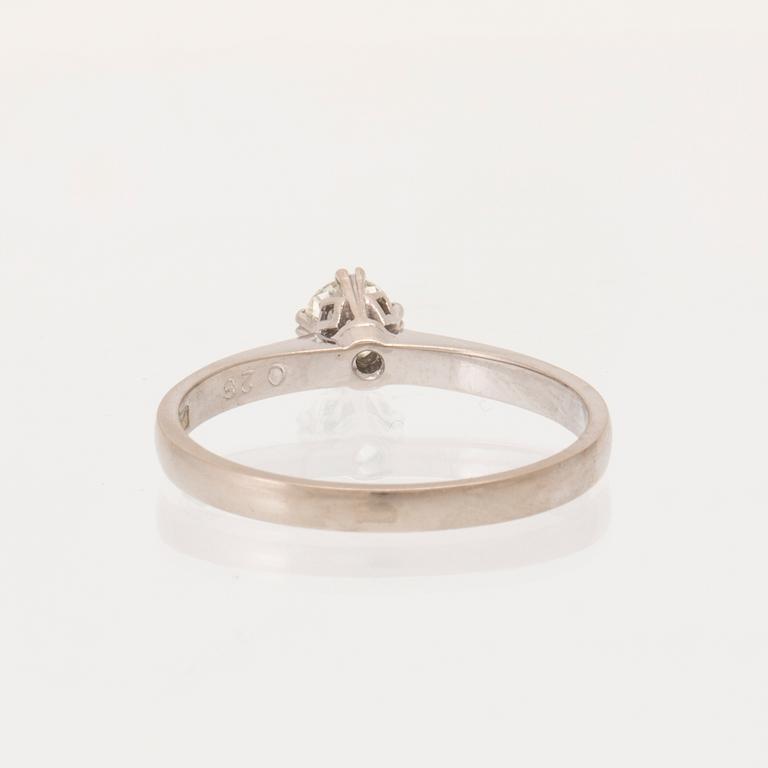 An 18K white gold solitaire ring set with a round brilliant-cut diamond.