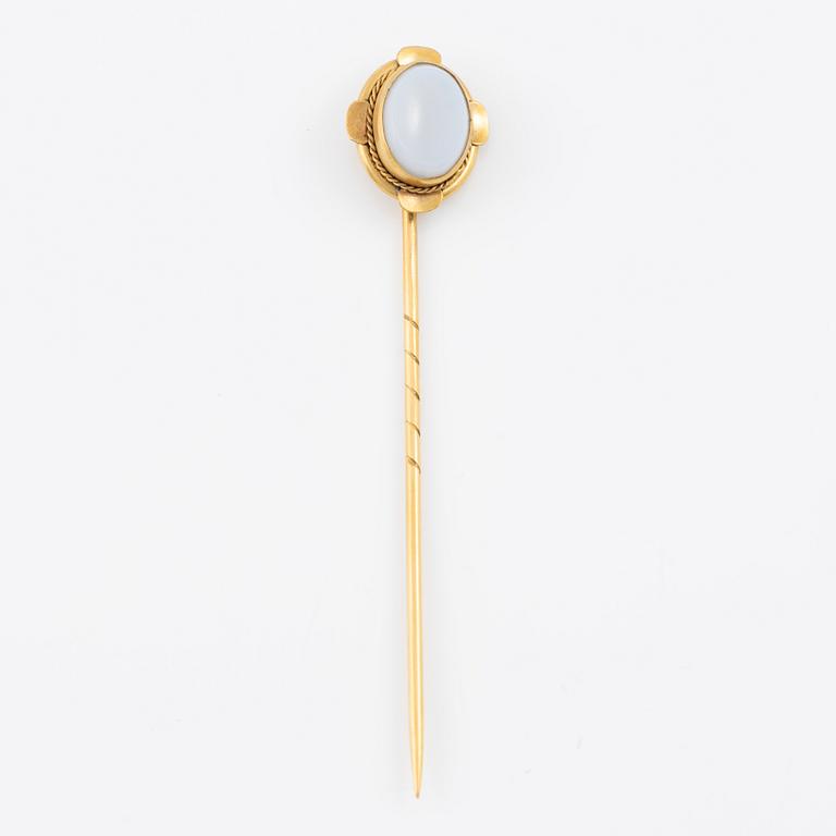Brooch pin of low-grade gold with a white-blue stone.