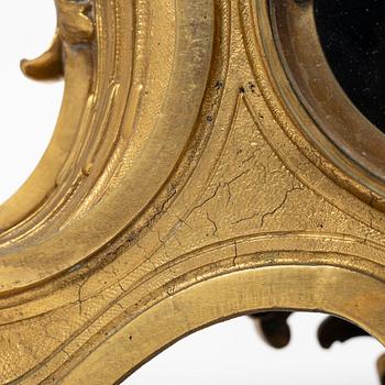 A Rococo style mantle clock and pair of candelabra, France, late 19th Century.