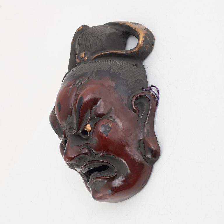A Japanese lacquered wooden mask, 20th century. Signed.