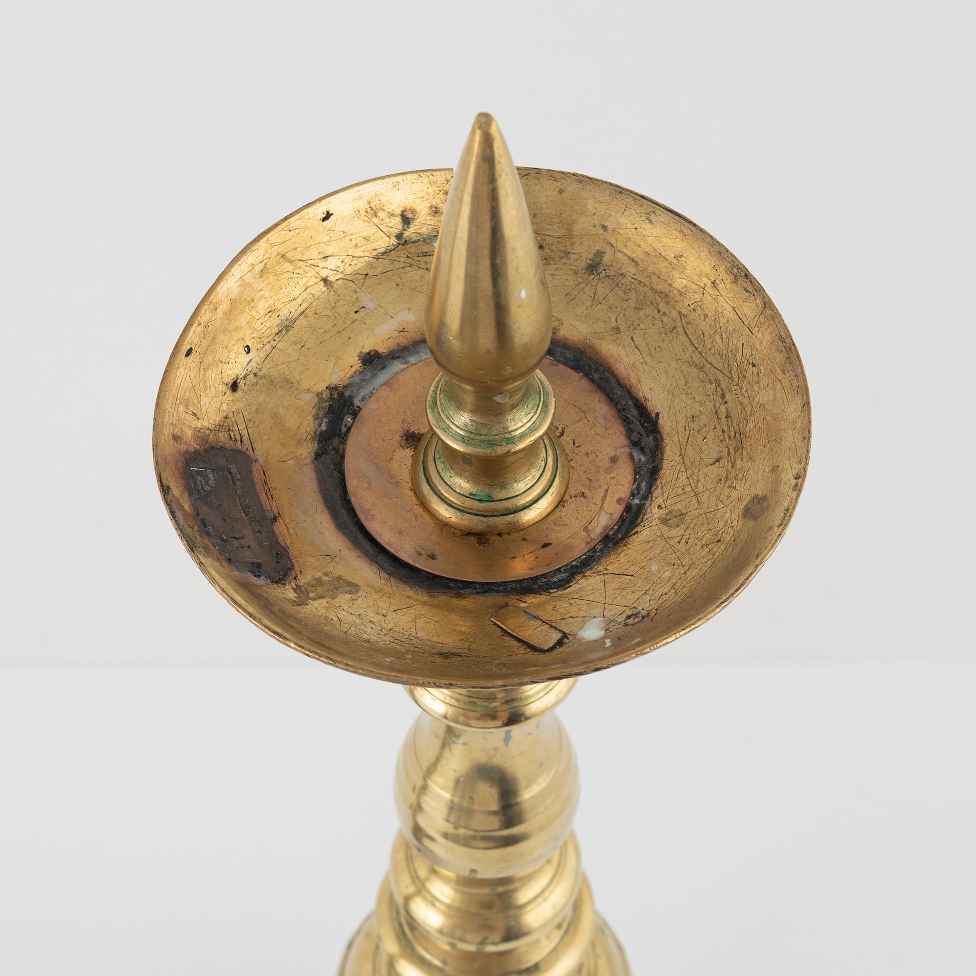 A pair of brass candle sticks, around 1700.