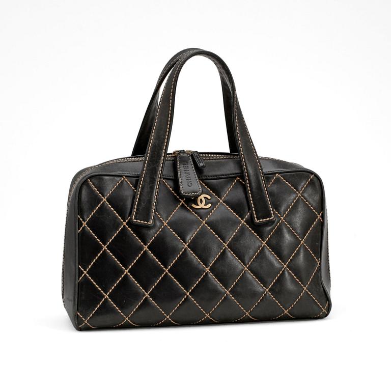 CHANEL, a black leather bag with beige stitching.