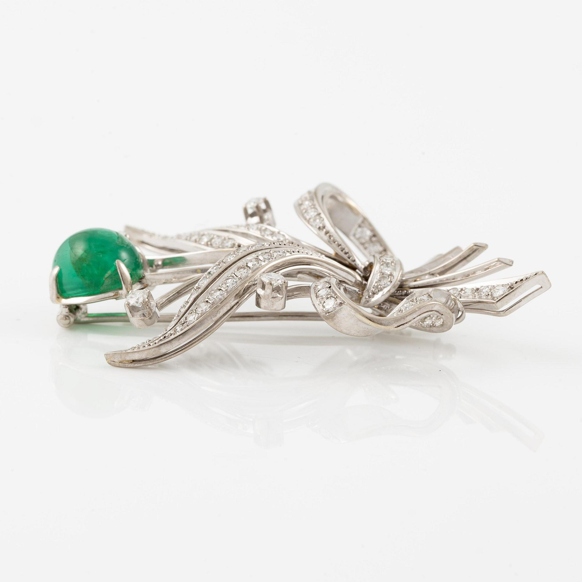 A brooch in 18K white gold with a cabochon-cut emerald.