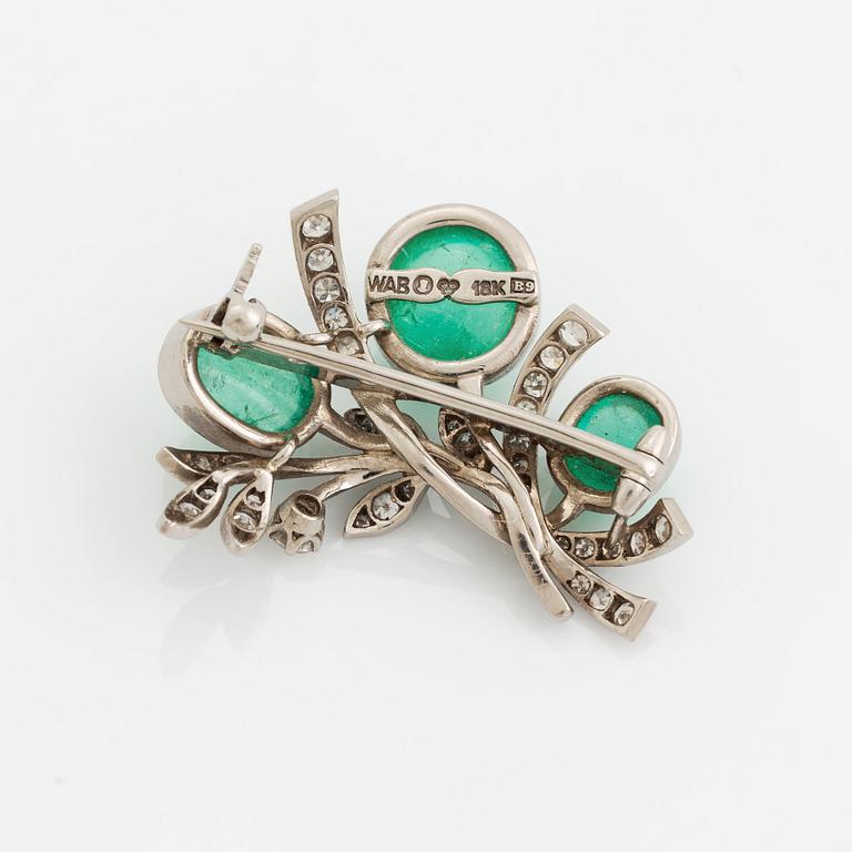 A WA Bolin brooch in 18K white gold set with a cabochon-cut emerald and eight-cut diamonds.