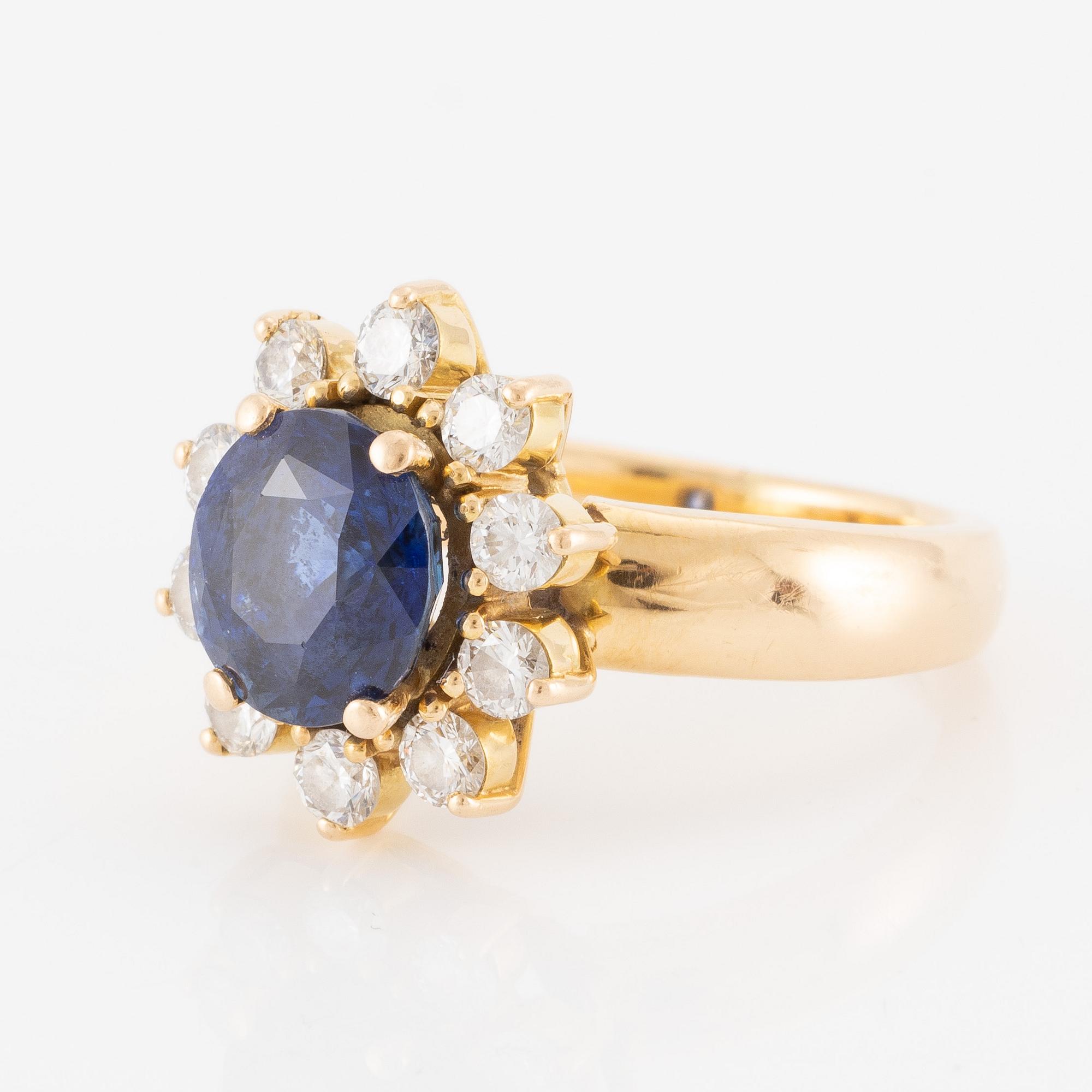 Ring 18K guld med en fasettslipad safir och runda briljantslipade diamanter.