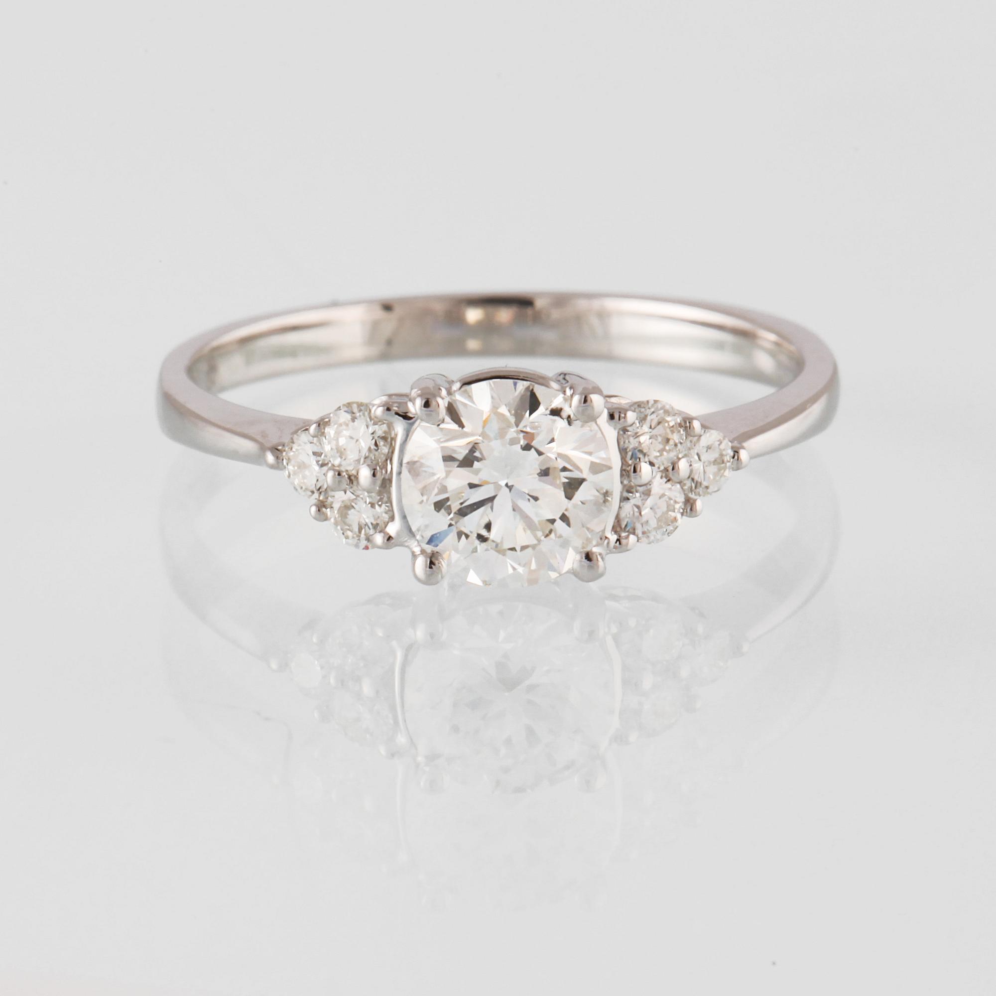 RING, 18K vitguld med en briljantslipad diamant 0.71 ct samt små briljantslipade diamanter 0.18 ct. Vikt 2,3 gram.