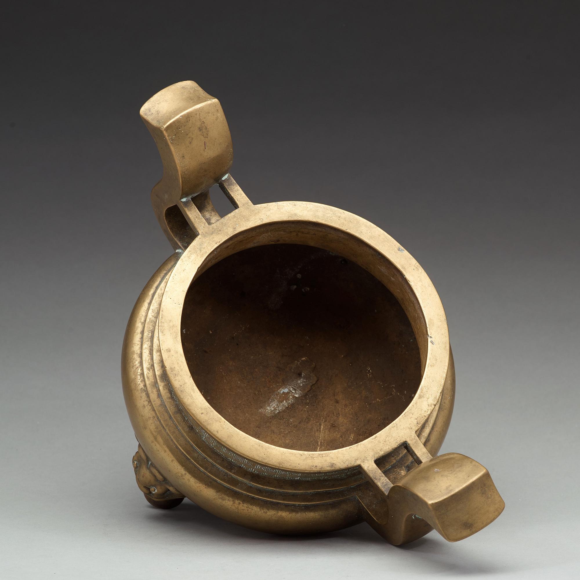 A large brass tripod censer, Qing dynasty (1644-1912).
