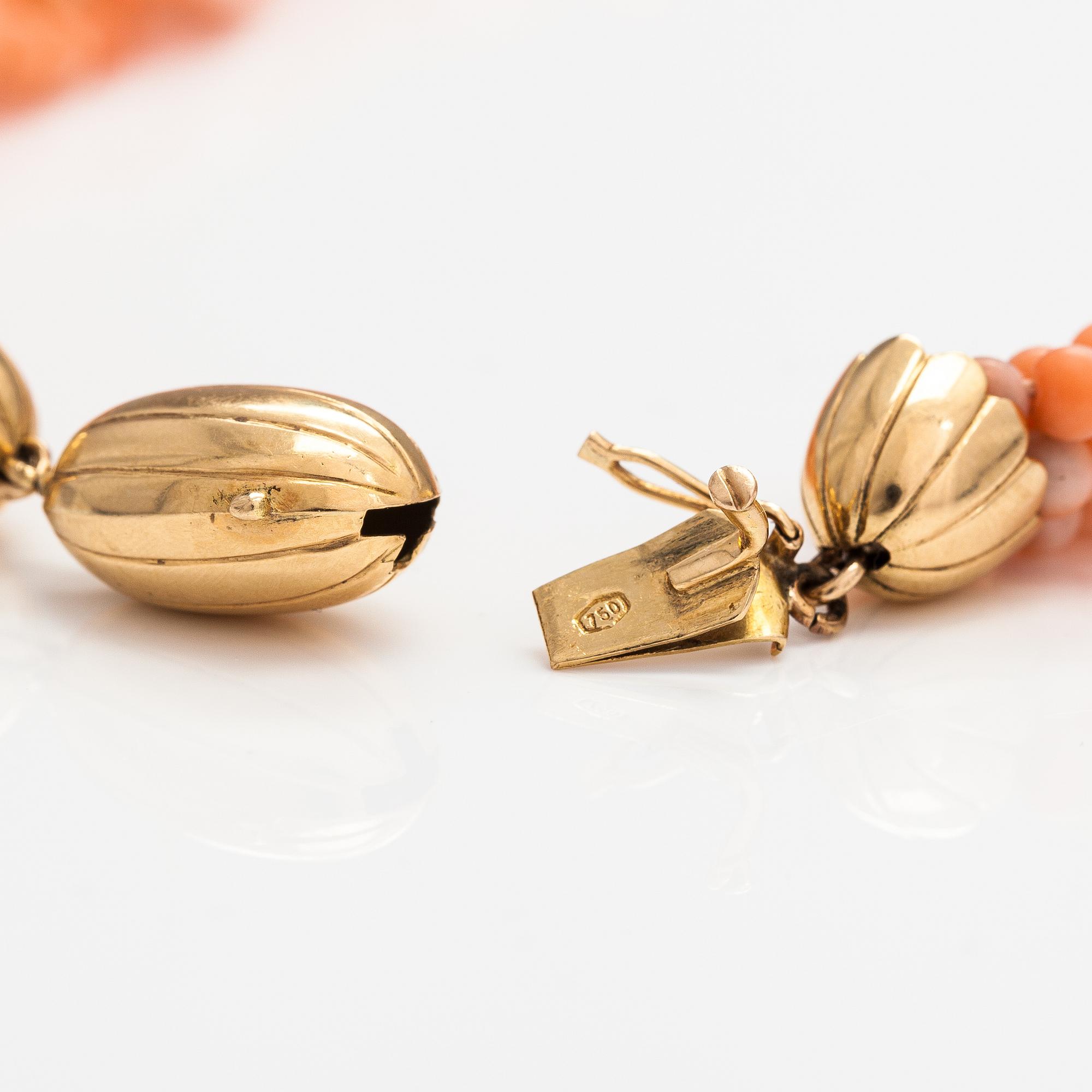 A 6-strand pearl collier with coral pearls and an 18K gold clasp.