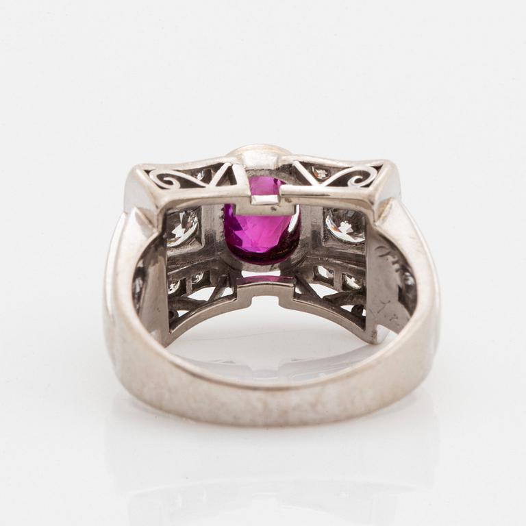 An 18K white gold ring set with a faceted ruby and round brilliant- and eight-cut diamonds.