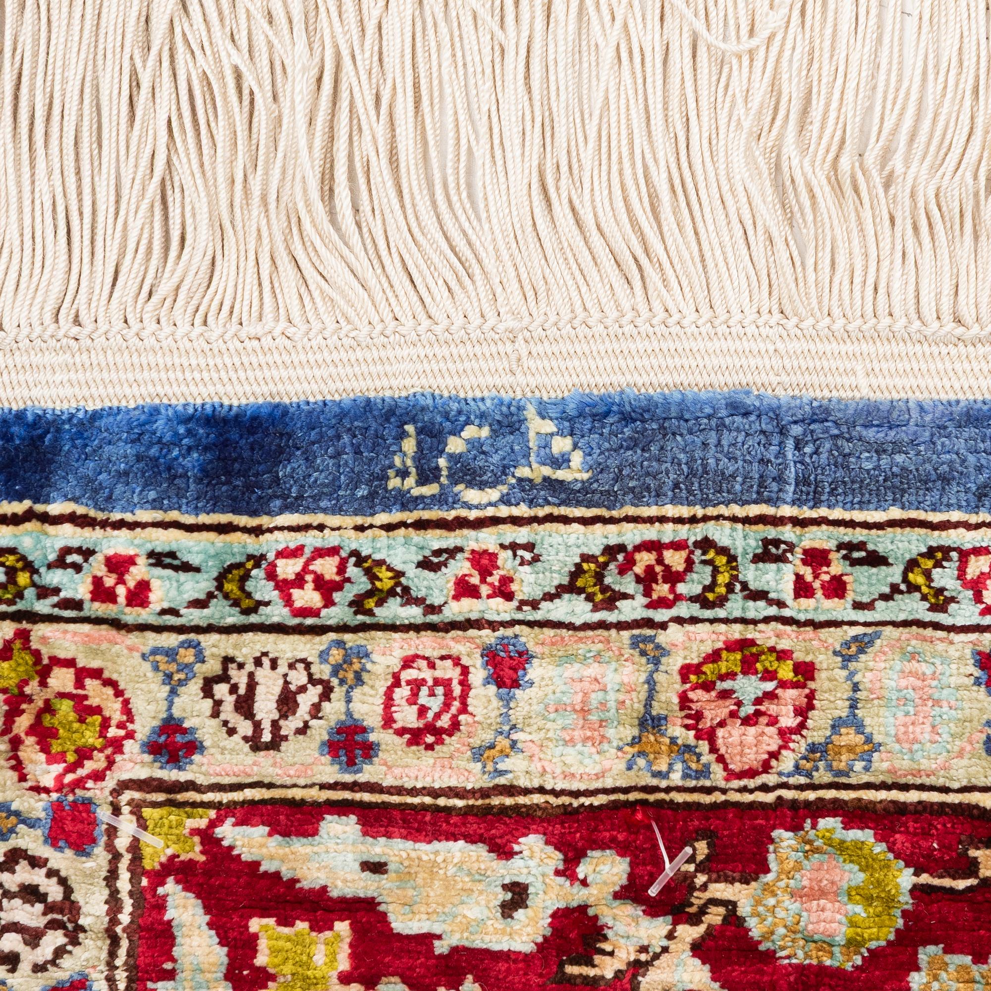 An Oriental silk rug, signed, c. 125 x 85 cm.