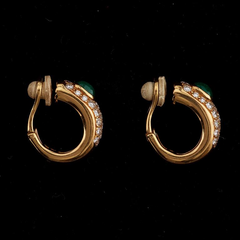A pair of Cartier earrings set with emeralds and brilliant cut diamonds.