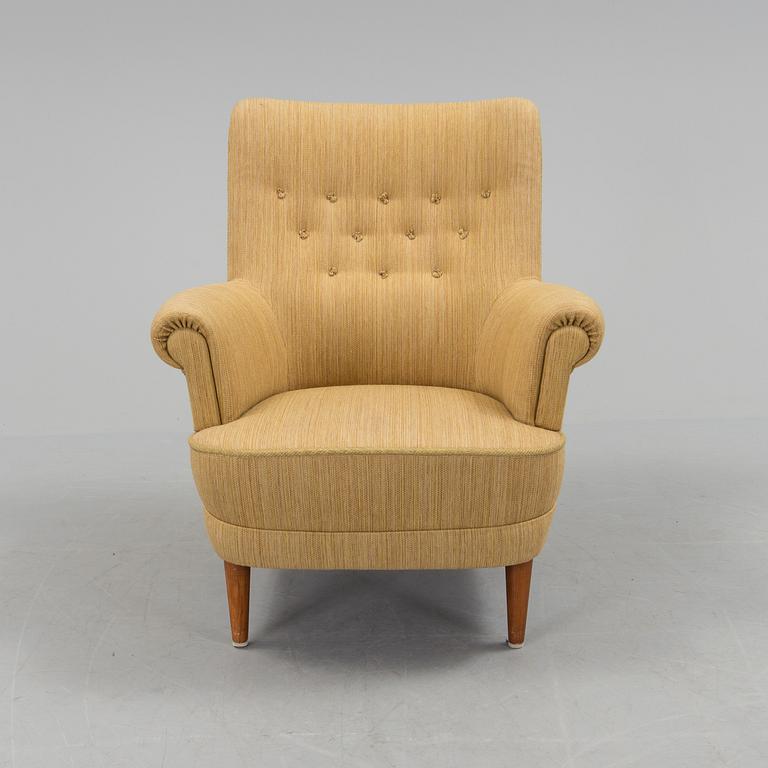 A mid 20th century armchair "Hemmakväll" designed by Carl Malmsten .