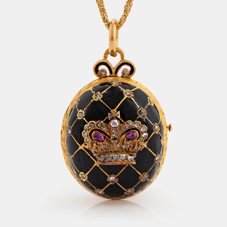 An egg shaped locket in 18K gold and black enamel set with rose-cut diamonds and rubies.