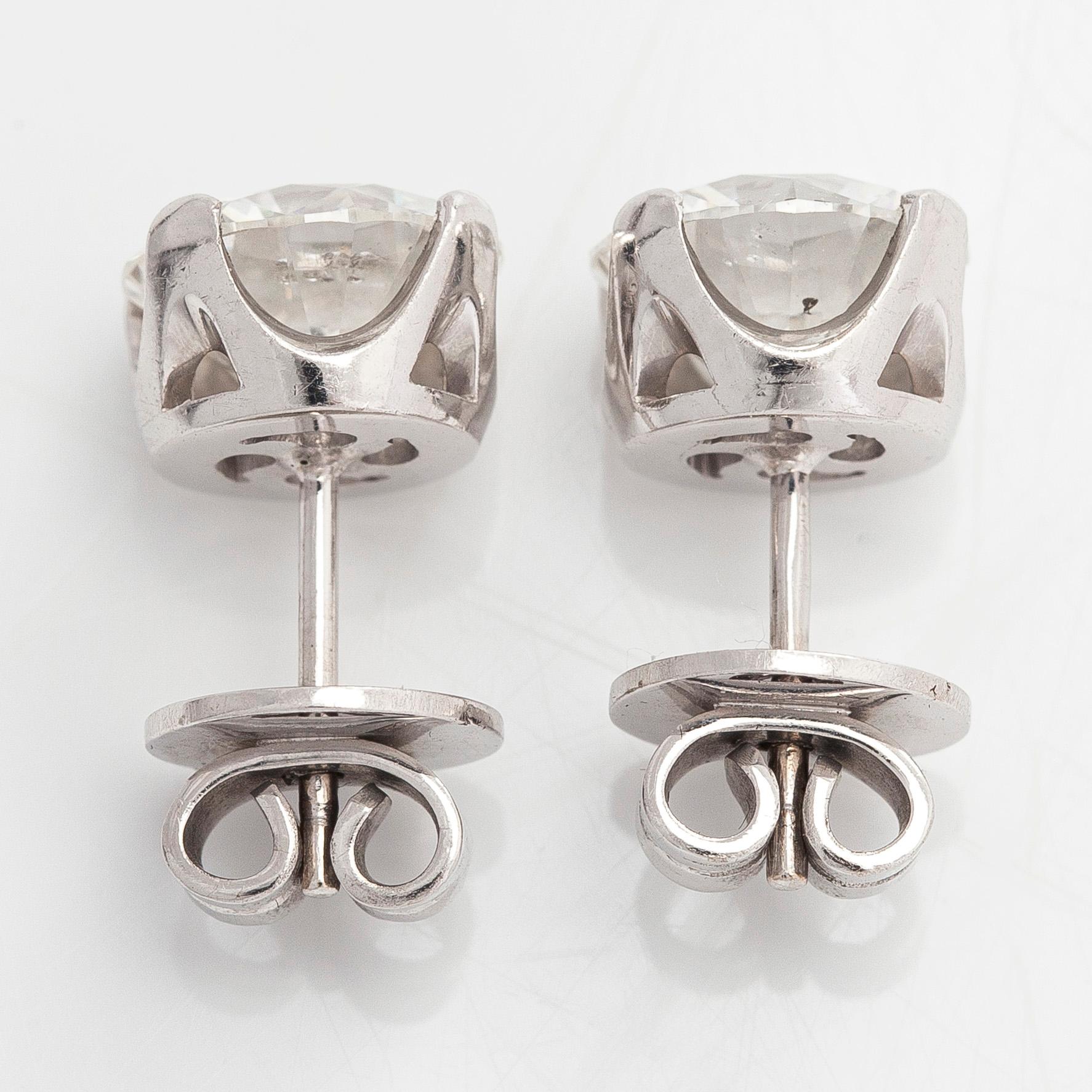 A pair of brilliant-cut diamond stud earrings in 18K white gold.