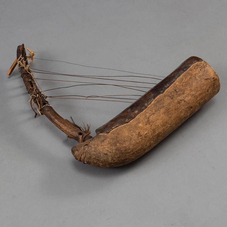 A STRING INSTRUMENT, wood, leather and rope, Africa first half of the 20th century, length 39,5 cm.