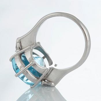 An 18K white gold ring set with a faceted topaz and two pear shaped brilliant-cut diamonds.