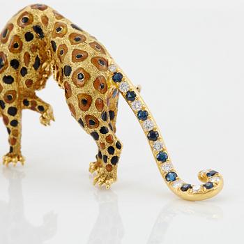 An 18K gold panther brooch set with round brilliant-cut diamonds, sapphires and emeralds.